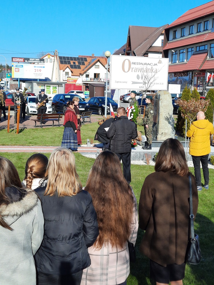 zdjęcie przedstawia grupę uczniów podczas uroczystości z okazji 11 listopada przed pomnikiem w Jabłonce