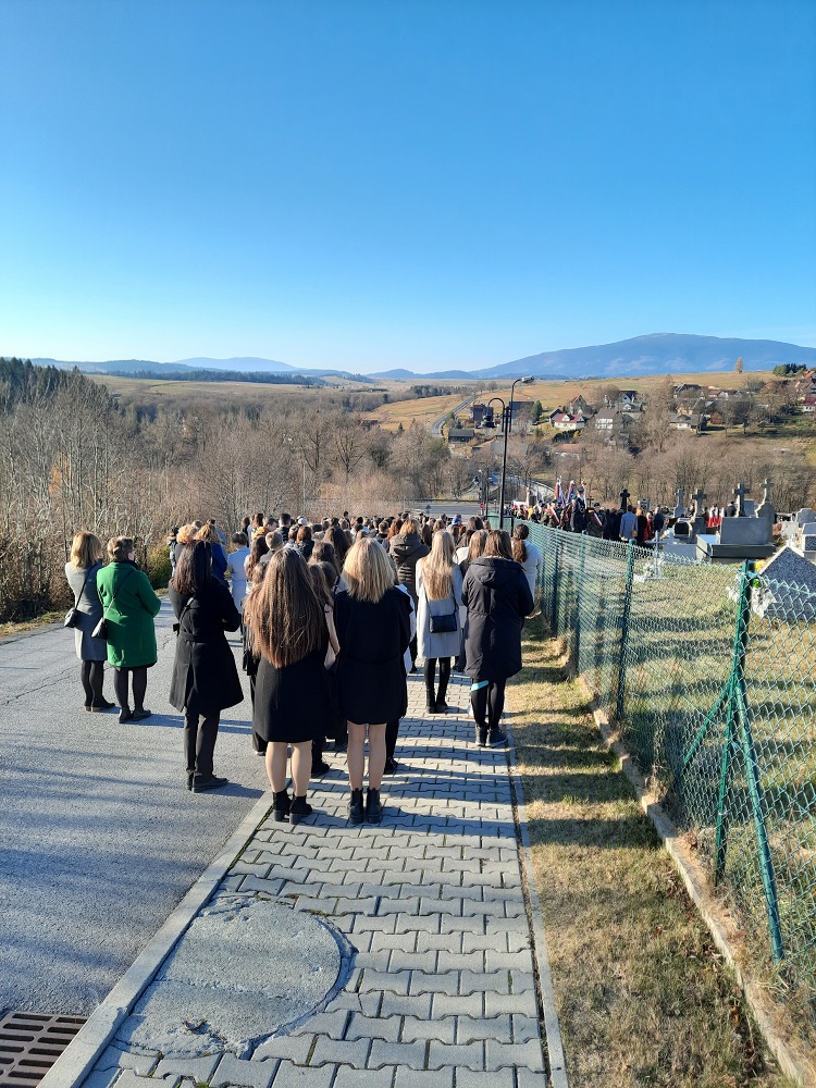 zdjęcie przedstawia grupę uczniów podczas uroczystości z okazji 11 listopada przy cmentarzu w Jabłonce