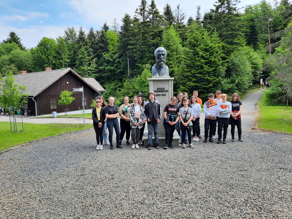 grupa uczniów przed pomnikiem Łukasiewicza