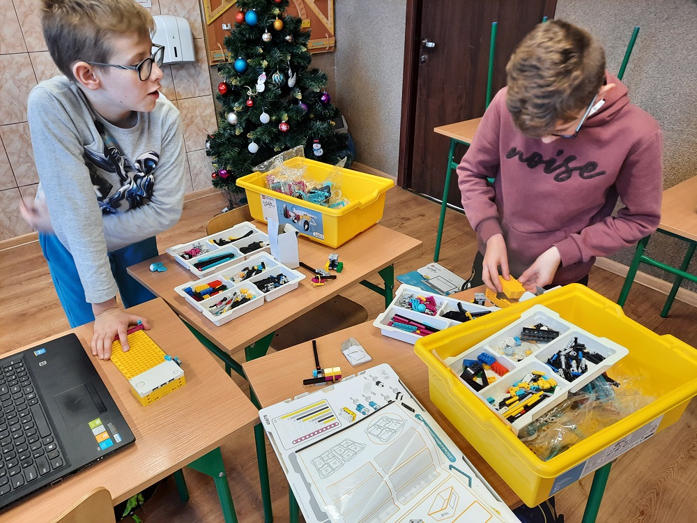 dwoje dzieci budujących robota z klocków Lego SPIKE Prime