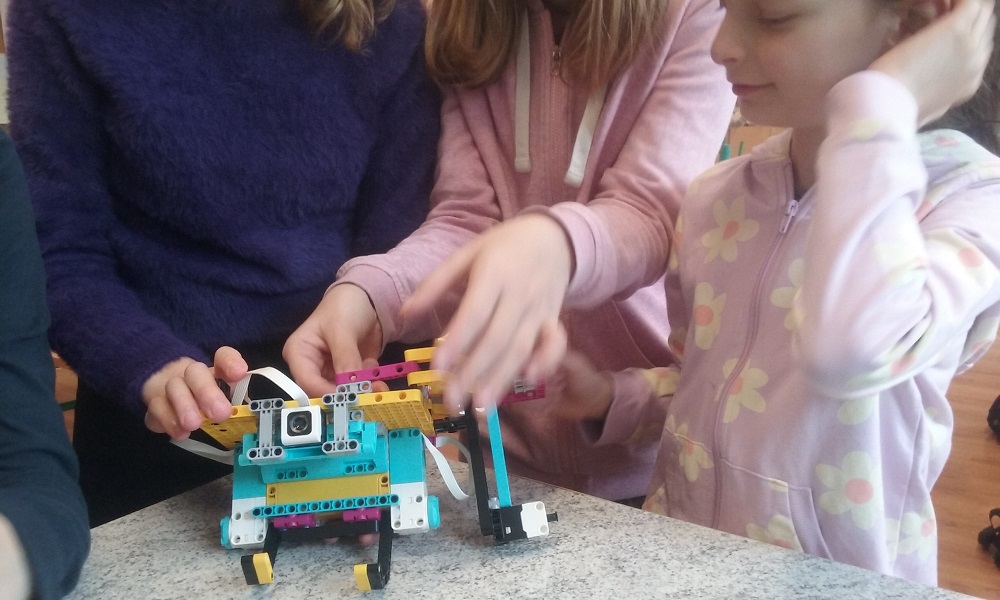 kilka uczniów podczas tworzenia projektu protezy z klocków Lego SPIKE Prime