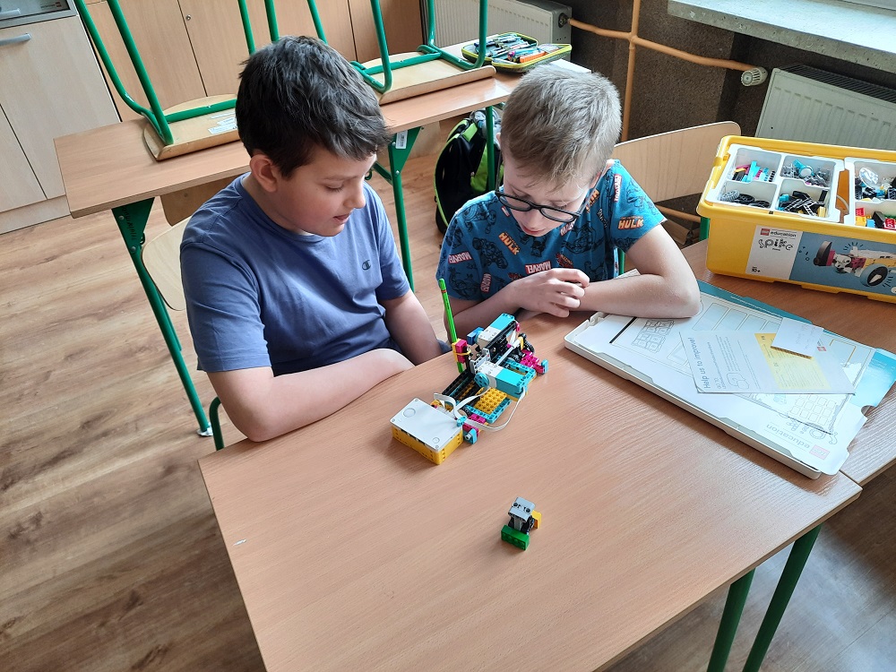 dwoje uczniów podczas budowania i testowania maszyny CNC z klocków Lego
