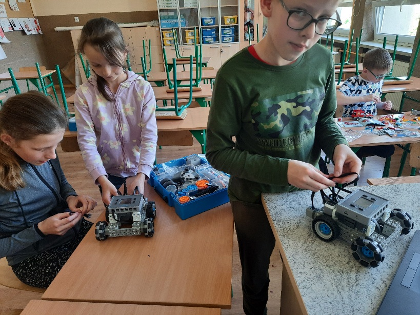 uczniowie budujący robota z klocków VEX