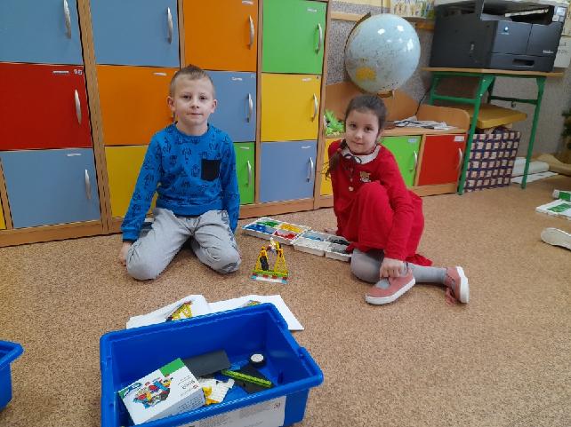 dwoje dzieci podczas budowania z klocków Lego