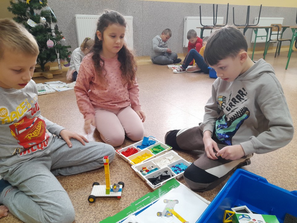 troje dzieci podczas budowania z klocków Lego