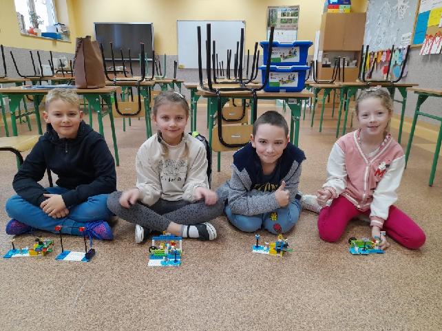 czworo uczniów podczas budowania z klocków Lego