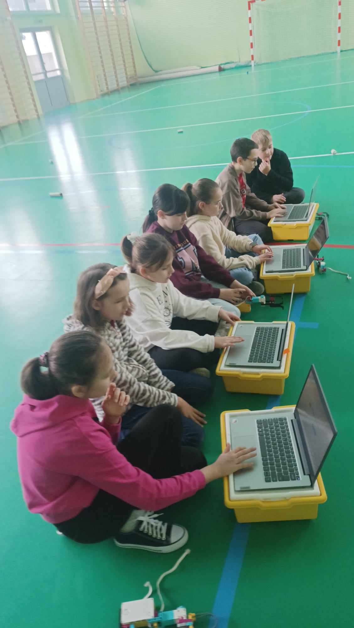 kilkoro uczniów piszących program na laptopach