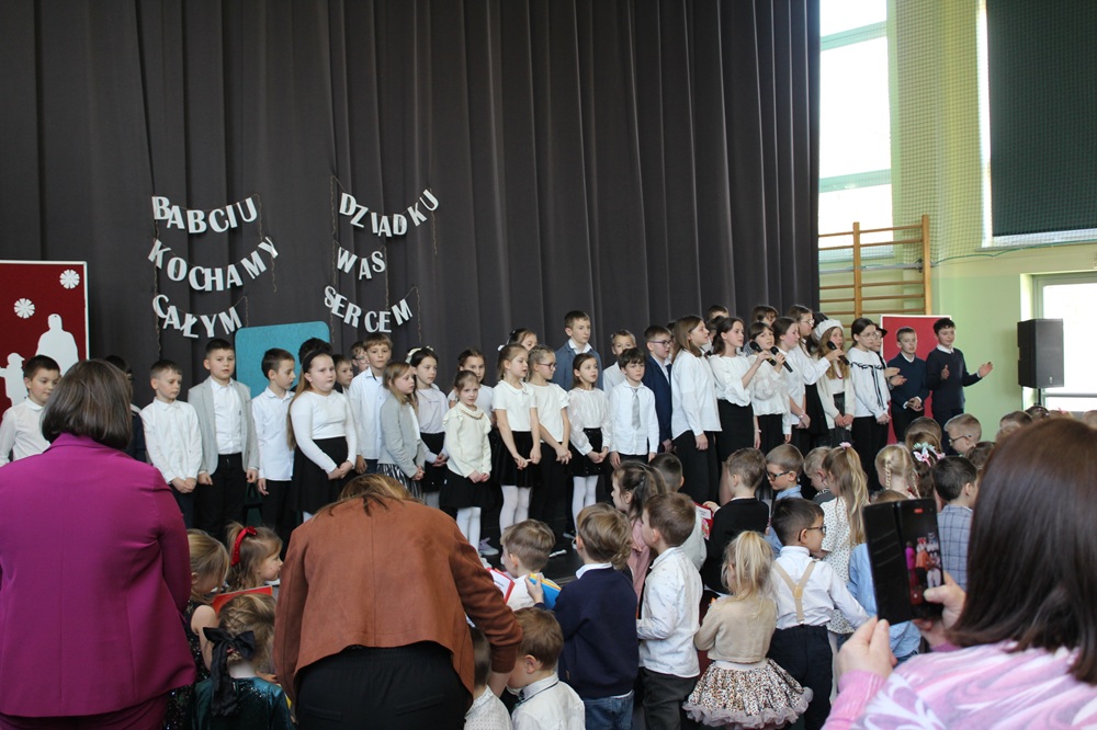 grupa dzieci oraz dorosłych podczas akademii z okazji dnia babci i dziadka