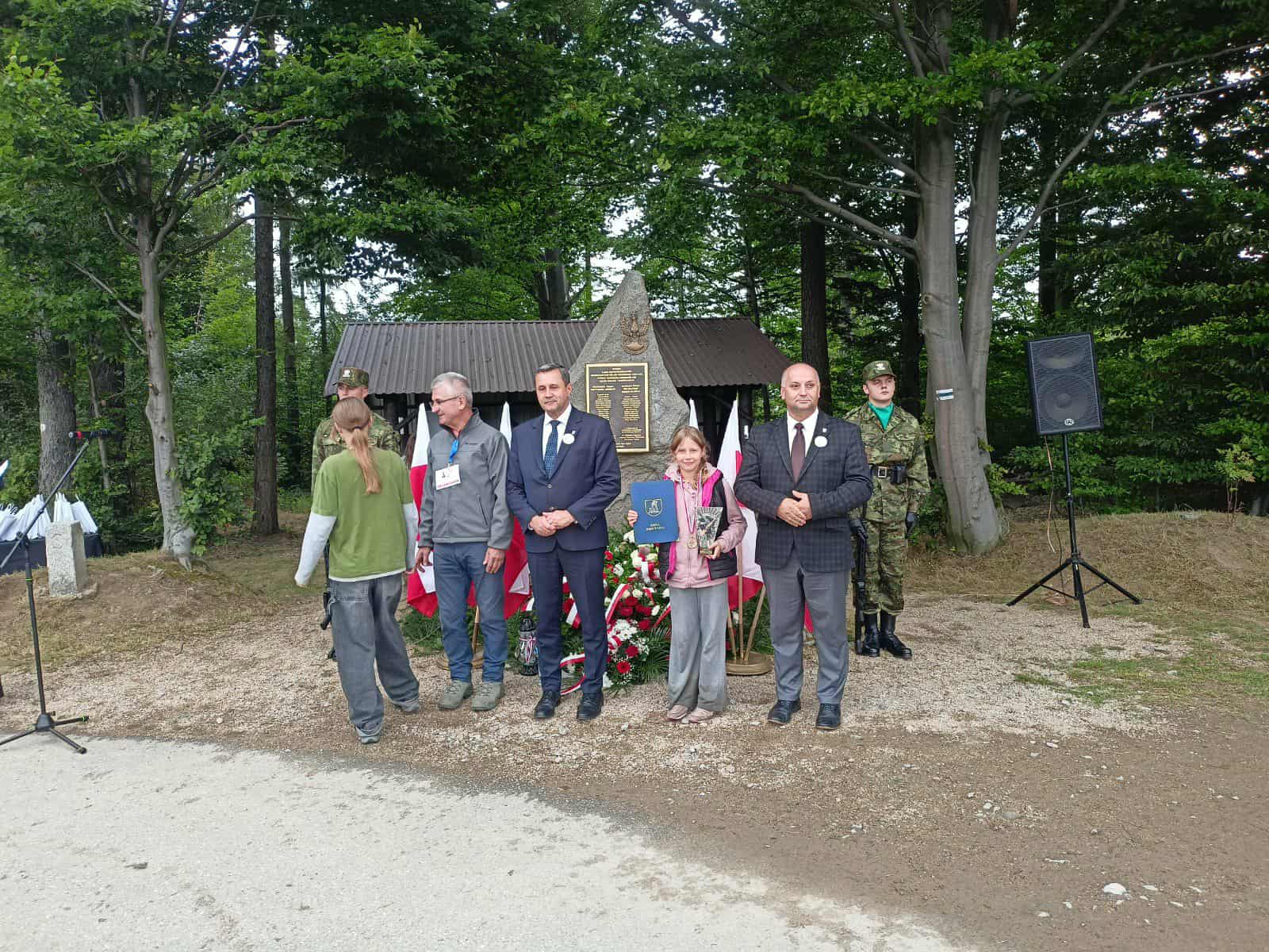 kilkoro uczniów z dorosłymi podczas wręcznia dyplomu