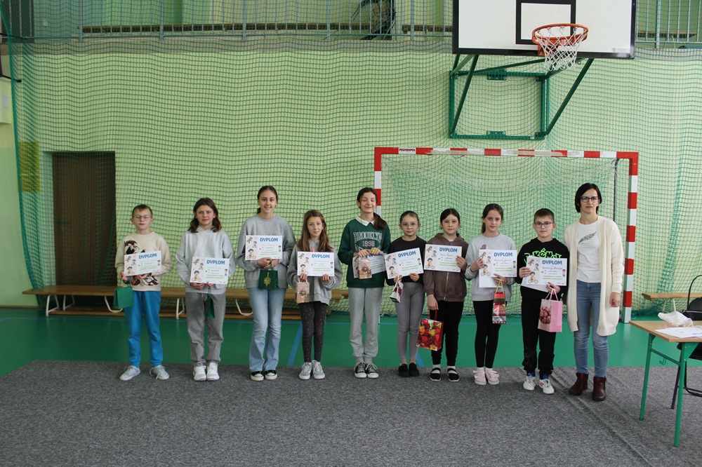 grupa uczniów z nauczycielem podczas wręcznia dyplomów i nagród za udział w konkursie