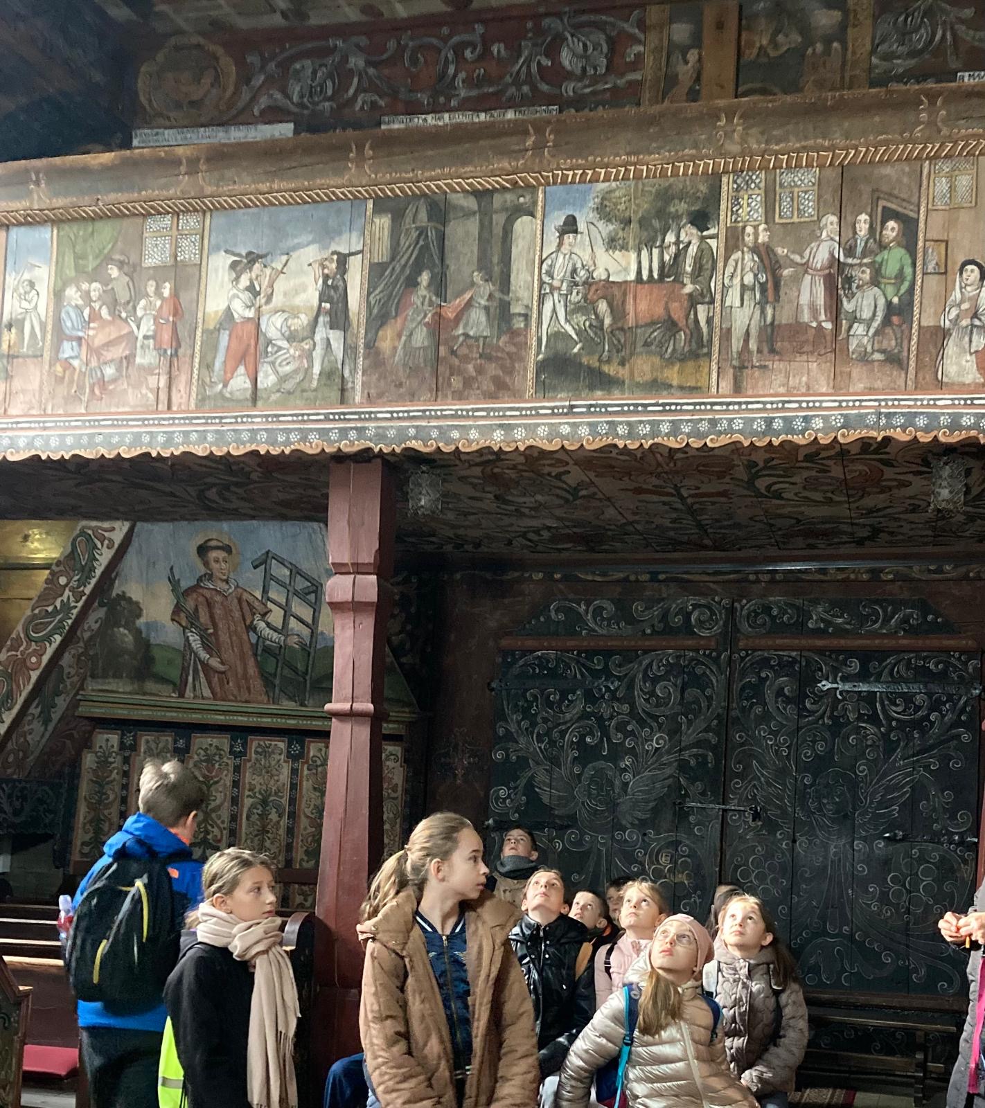 kilkoro uczniów zwiedzających kościół w Orawce