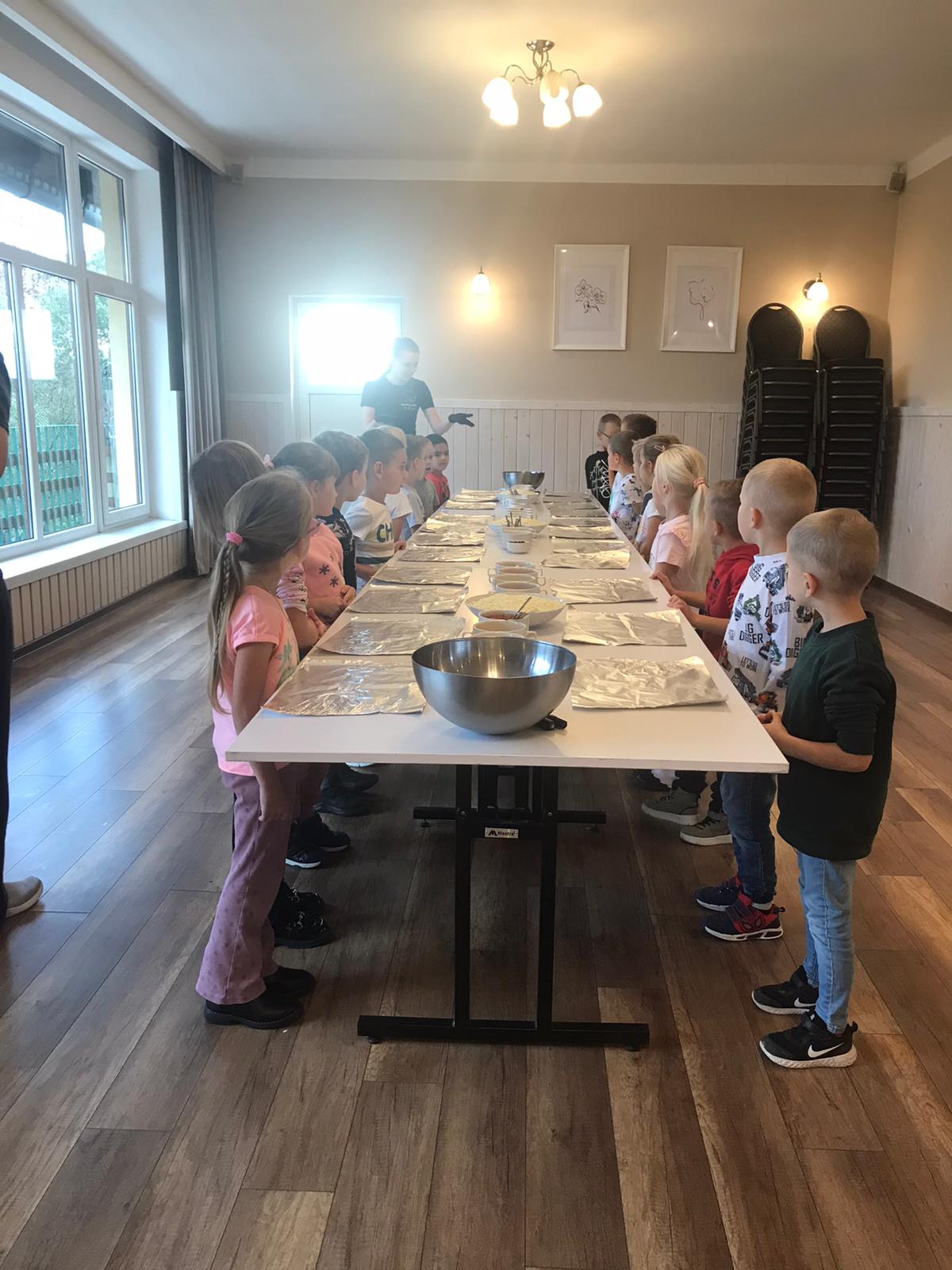 kilkanaścioro dzieci podczas robienia pizzy
